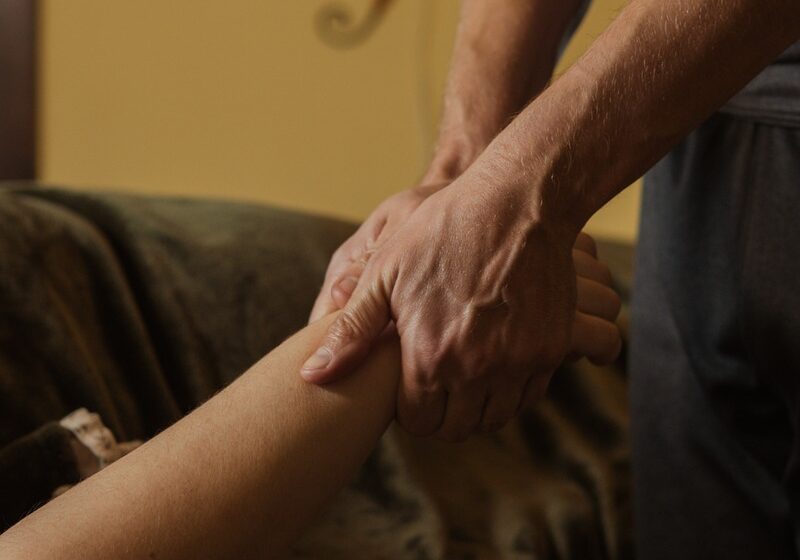 closeup of two hands massaging client's forearm